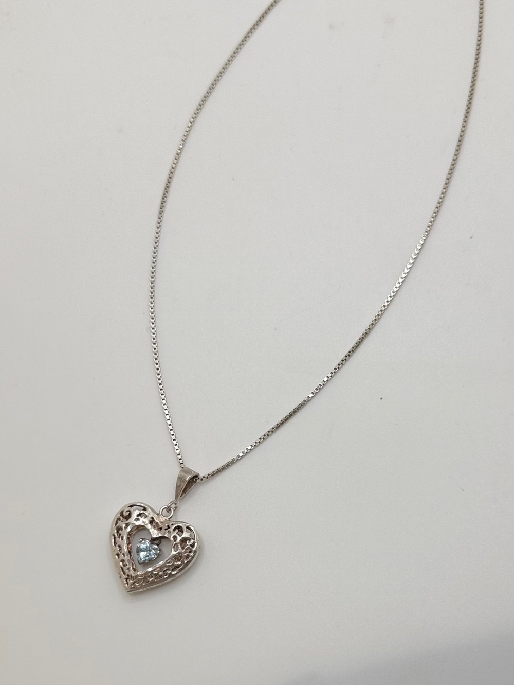 Sterling Silver heart pendent with blue topaz gem in the middle
